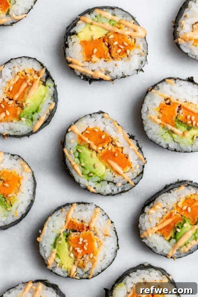 Effortless Elegance: 20 Stunning Date Night Dinners 14 Delicious sweet potato tempura and avocado sushi rolls, sliced and covered in toasted sesame seeds and drizzled with sriracha mayo, arranged on a marble board.