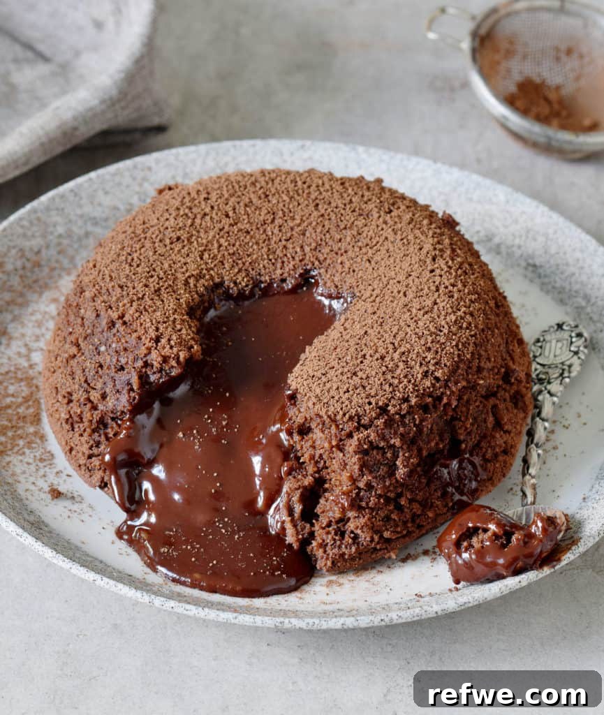 Effortless Elegance: 20 Stunning Date Night Dinners 20 Rich molten chocolate spilling enticingly from the center of a warm vegan lava cake, served on a grey plate with a silver spoon to the side, ready to be enjoyed.