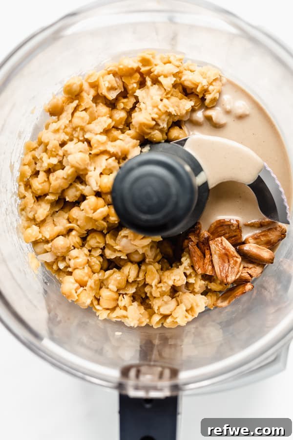 Everything Bagel Seasoned Hummus 3 Raw ingredients for Everything Bagel Hummus in a food processor: chickpeas, tahini, and roasted garlic.