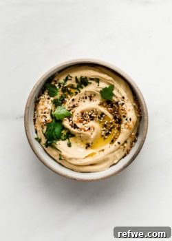 Everything bagel hummus in a small bowl topped with everything bagel spice