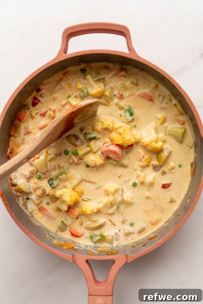 Vegetables swimming in a rich, creamy cashew sauce in a pan, simmering gently.