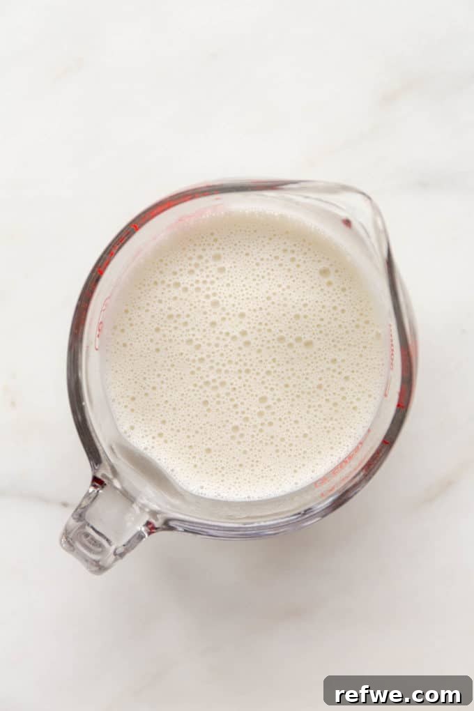 Smooth, creamy cashew milk in a measuring cup, prepared for the korma sauce.