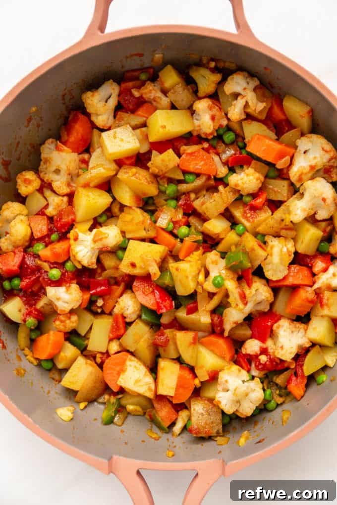 Sautéed vegetables and tomatoes cooking together in a pan, colorful and fragrant.