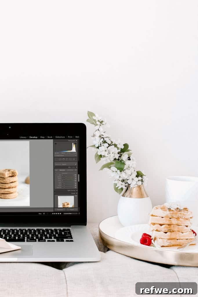 A laptop and a plate of waffles on a couch, illustrating a cozy food photography editing setup
