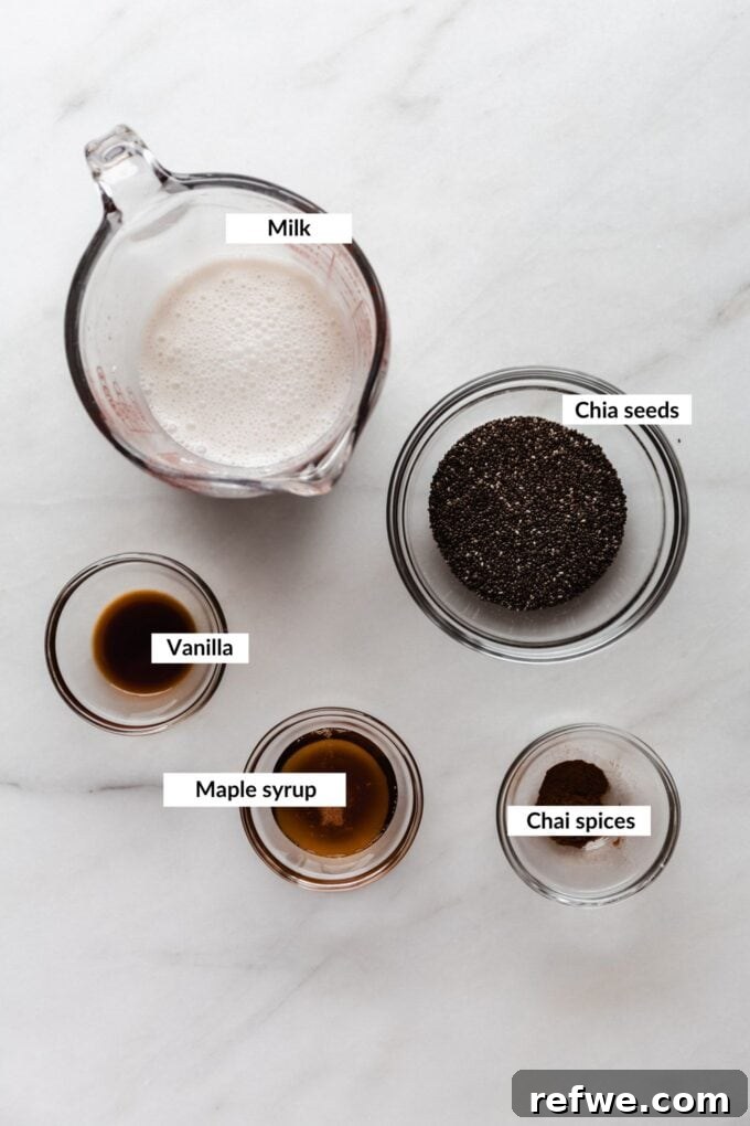 Spiced Chai Chia Dream 3 A flat lay image showcasing the fresh ingredients required to make chai latte chia pudding, including milk, chia seeds, and various chai spices laid out on a clean surface.
