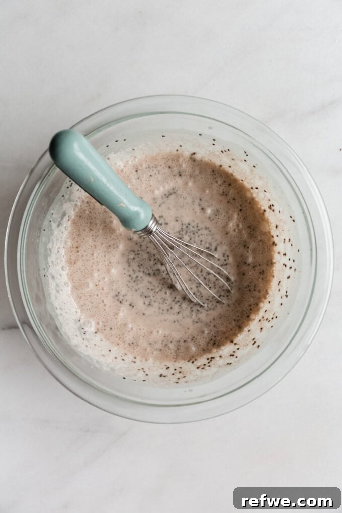 Spiced Chai Chia Dream 5 An overhead shot of a mixing bowl where chia seeds, chai spices, and milk are actively being whisked together, showing the initial stages of thickening.