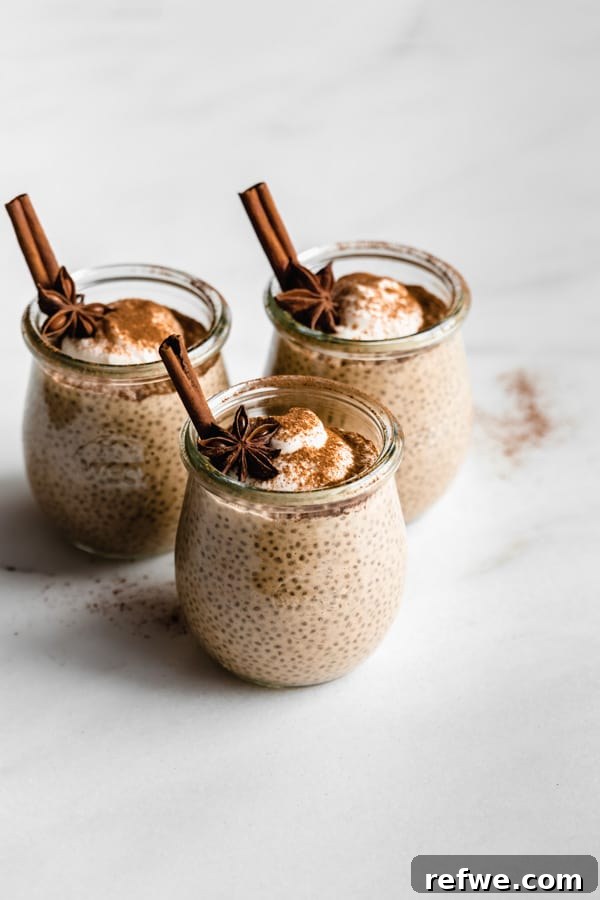 Spiced Chai Chia Dream 7 Three beautifully presented cups of chai latte chia pudding, garnished with cinnamon sticks and a sprinkle of spices, ready for serving.
