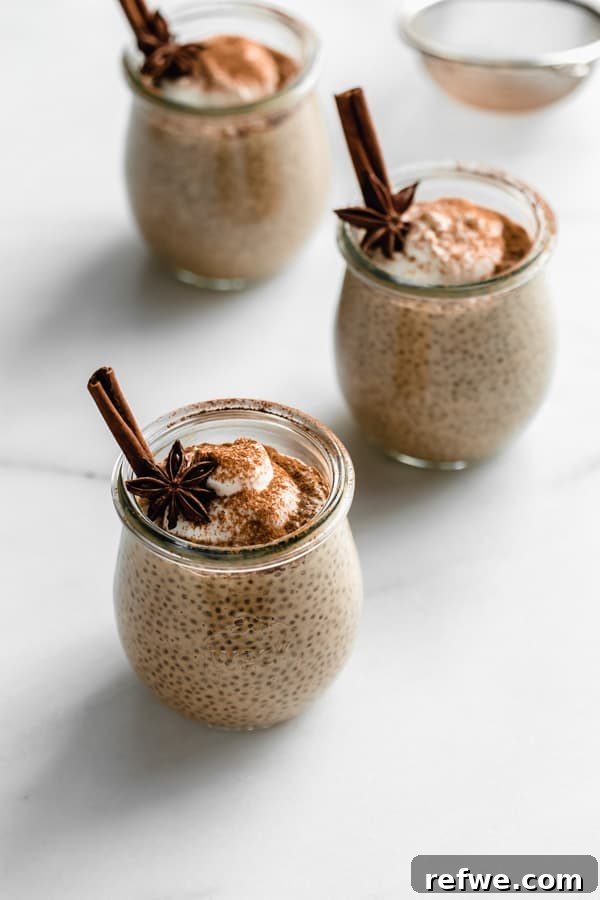 Spiced Chai Chia Dream 8 A charming arrangement of three chai latte chia pudding cups, artfully placed on a pristine white marble board, ready for a cozy breakfast or delightful snack.