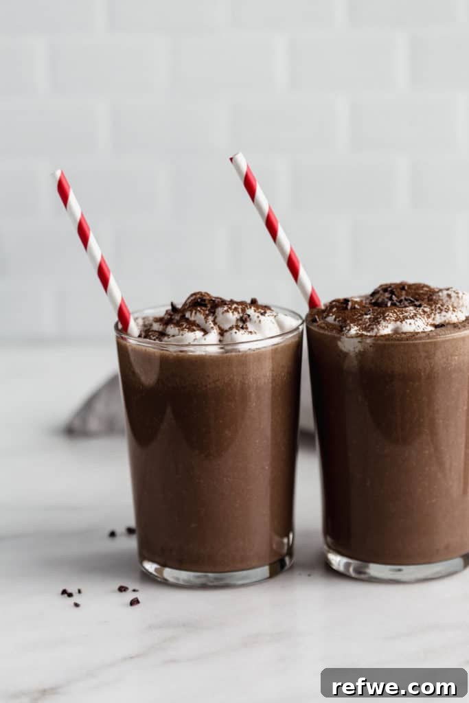 Blended Cocoa Chill 2 Two glasses of healthy frozen hot chocolate garnished with coconut whipped cream and chocolate shavings.