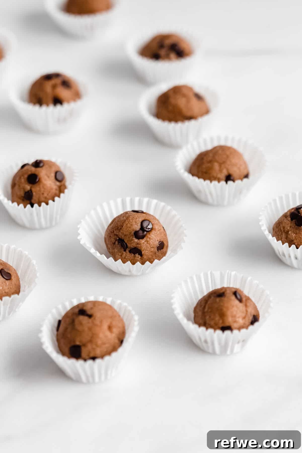 Protein Packed Cookie Dough Bites 9 A beautifully arranged stack of chocolate chip cookie dough protein balls on a elegant marble counter.