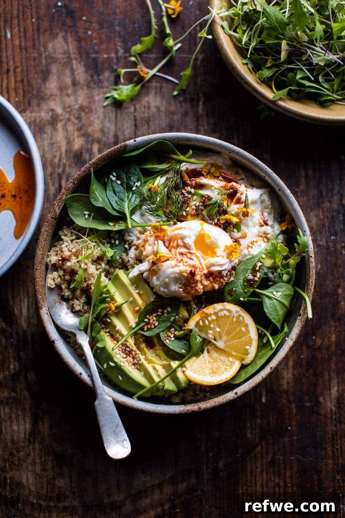 A delightful bowl of Turkish eggs served with fresh greens and a zesty lemon wedge, creating a unique breakfast experience.