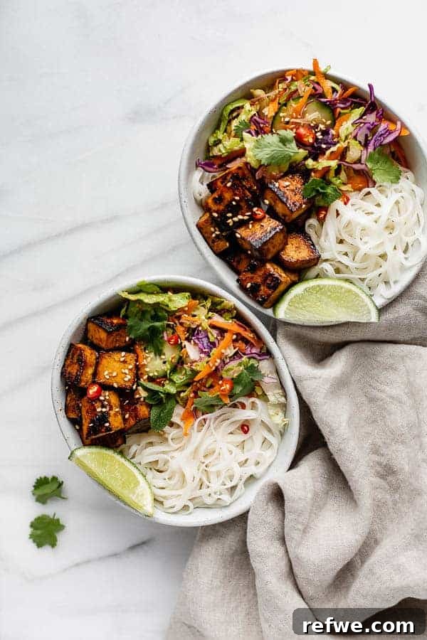 A delightful Vietnamese noodle bowl showcasing aromatic lemongrass tofu nestled amongst fresh rice noodles and vibrant vegetables.