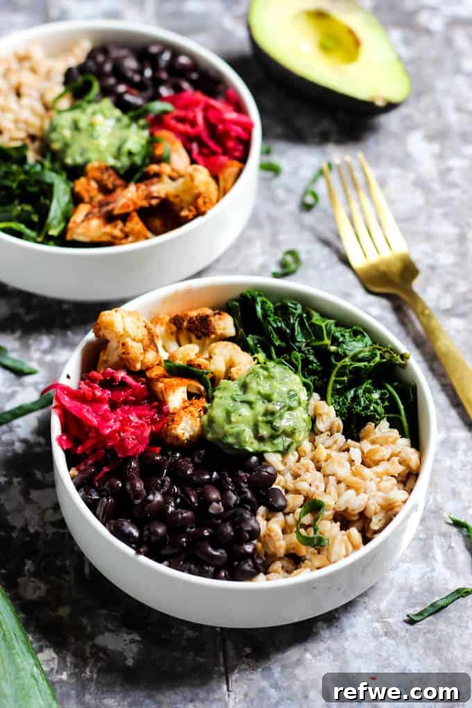 A wholesome black bean bowl featuring fluffy rice, roasted cauliflower, and a vibrant green avocado pesto.