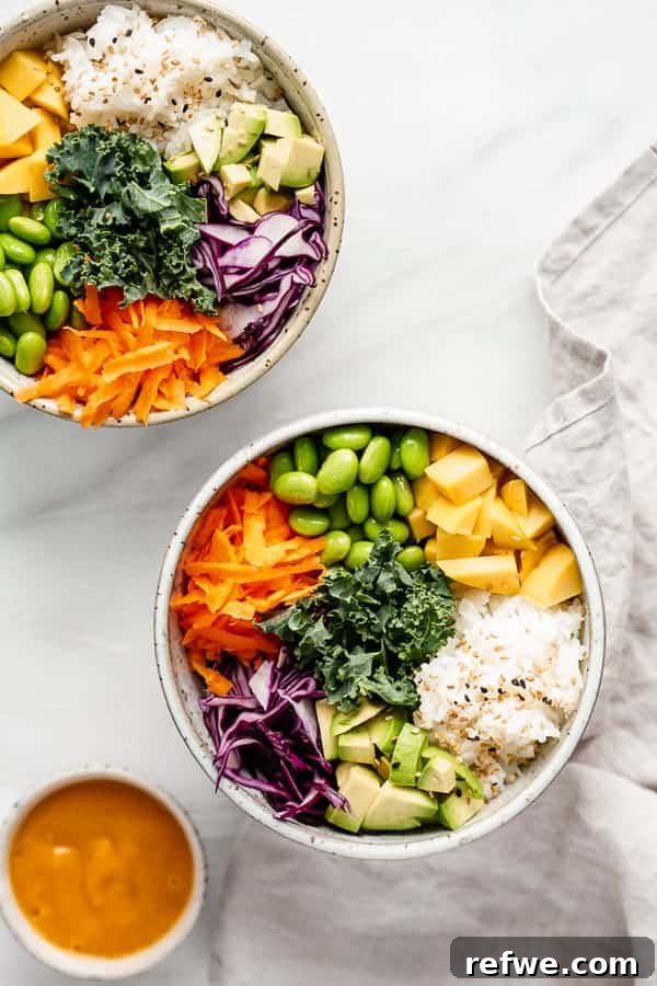 A vibrant vegan Buddha bowl featuring juicy mango cubes, fluffy rice, and an assortment of fresh vegetables, all drizzled with a zesty spicy mango sauce.
