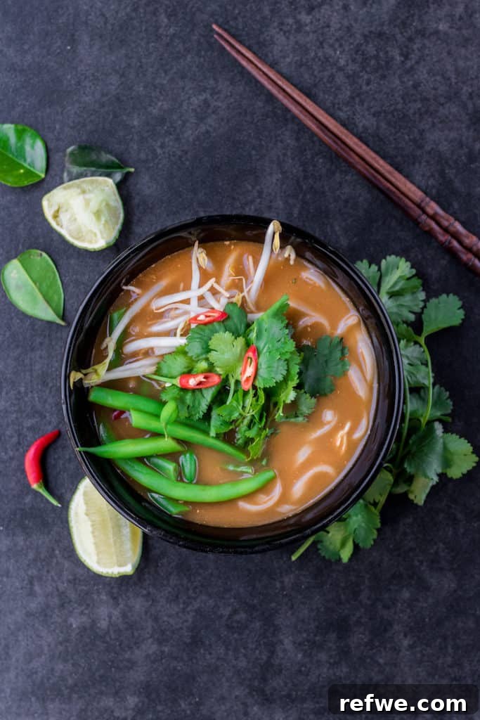 No-Fuss Tom Yum Soup 2 A steaming bowl of easy homemade Tom Yum soup with fresh herbs and noodles, ready to be enjoyed.
