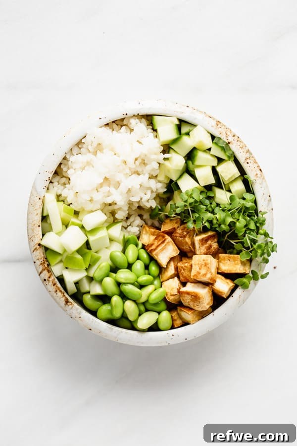 A vegan poke bowl with rice, vegetables, and the addition of crispy tofu.