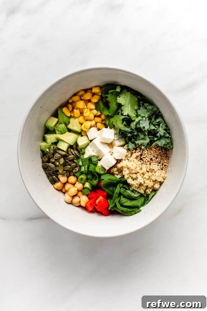 Vibrant Green Goddess Quinoa Bowl 2 A vibrant bowl of quinoa power bowl with fresh vegetables, feta cheese, and various seeds