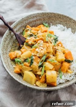 roasted sweet potato and pineapple curry in a bowl with rice and fresh cilantro.