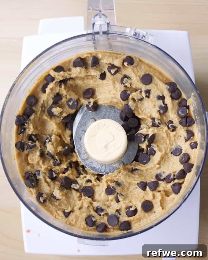 21 Amazing Meals from a Single Can of Beans 20 A food processor bowl filled with healthy chocolate chip cookie dough dip made from chickpeas