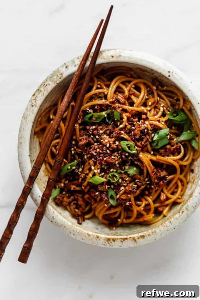 Plant-Based Dan Dan Delight 8 A beautifully prepared bowl of vegan dan dan noodles with chopsticks nestled on top, ready for serving.