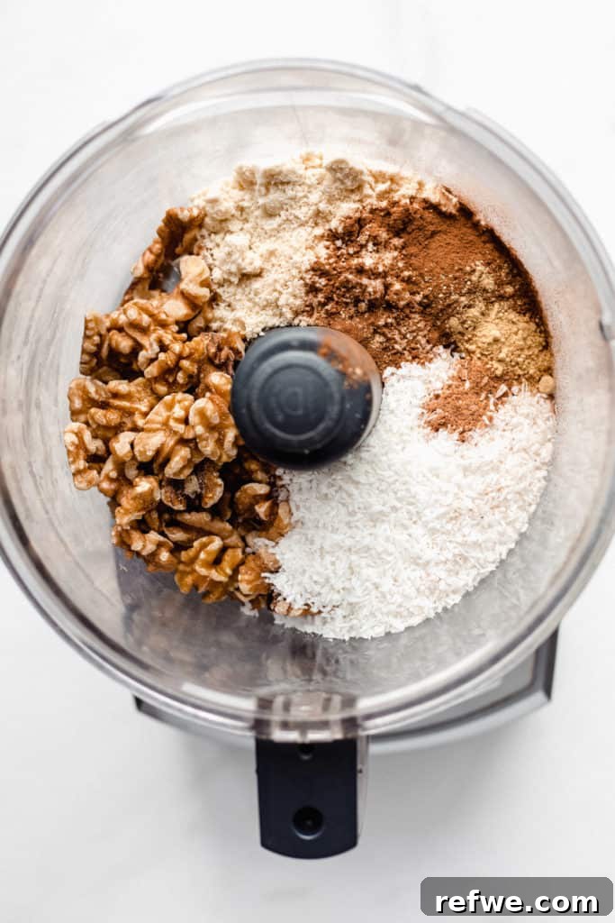 Guilt-Free Raw Vegan Carrot Cake 3 a food processor with shredded coconut and nuts in it