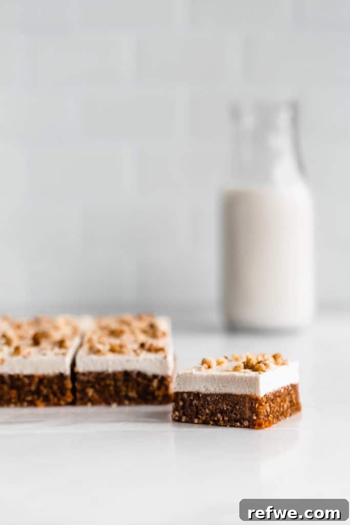 Guilt-Free Raw Vegan Carrot Cake 10 raw carrot cake bars on a marble counter with a bottle of milk in the background