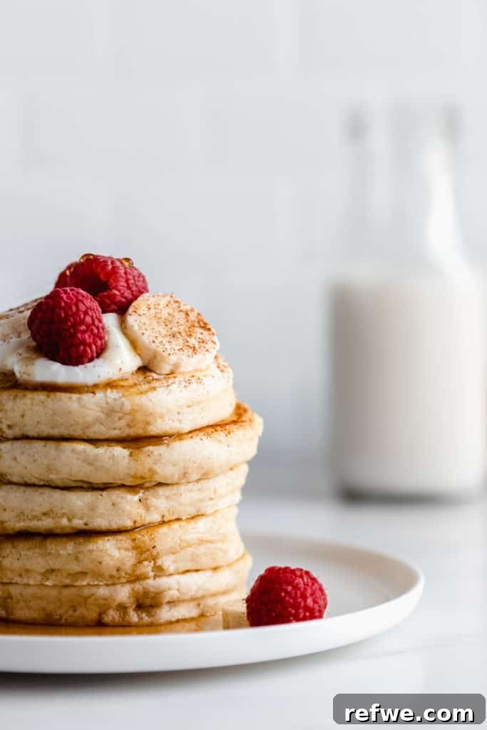 A close-up shot of a stack of golden, fluffy vegan oatmeal pancakes, perfectly cooked and ready to eat.
