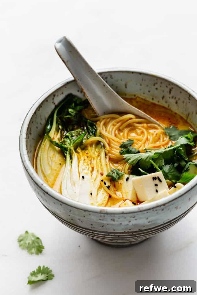 Effortless Vegetarian Laksa 5 A beautifully presented blue speckled bowl, filled to the brim with creamy laksa soup, ready to be enjoyed.