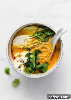 A bowl of vibrant vegetarian laksa with fresh bok choy and tender noodles.