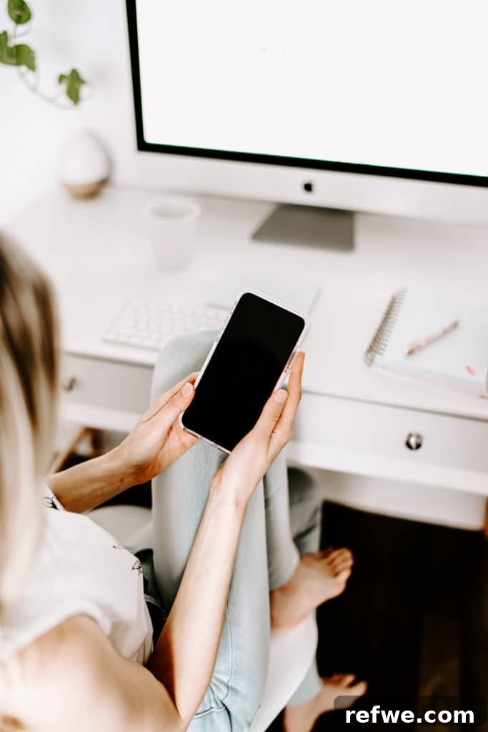 From Chaos to Calendar: Planning Your Instagram Content 2 A girl sitting at a white desk holding an iPhone