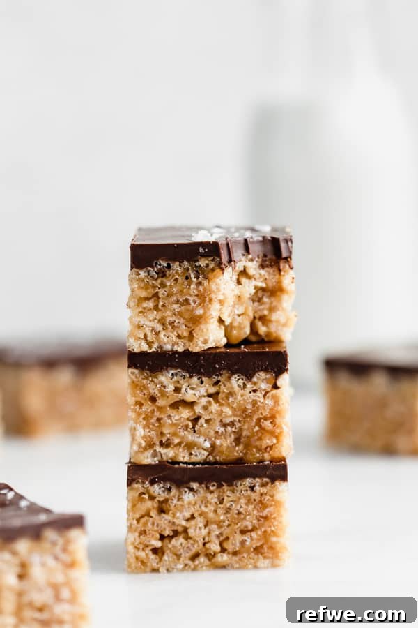 Crispy healthy chocolate Scotcheroos with a rich dark chocolate topping, showing their inviting texture.