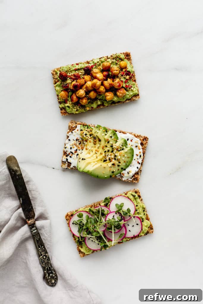 Avocado Toast: Three Creative Twists 2 Three Ryvita crispbreads generously topped with fresh avocado and various vibrant toppings, alongside a clean napkin and a knife, ready to be enjoyed.