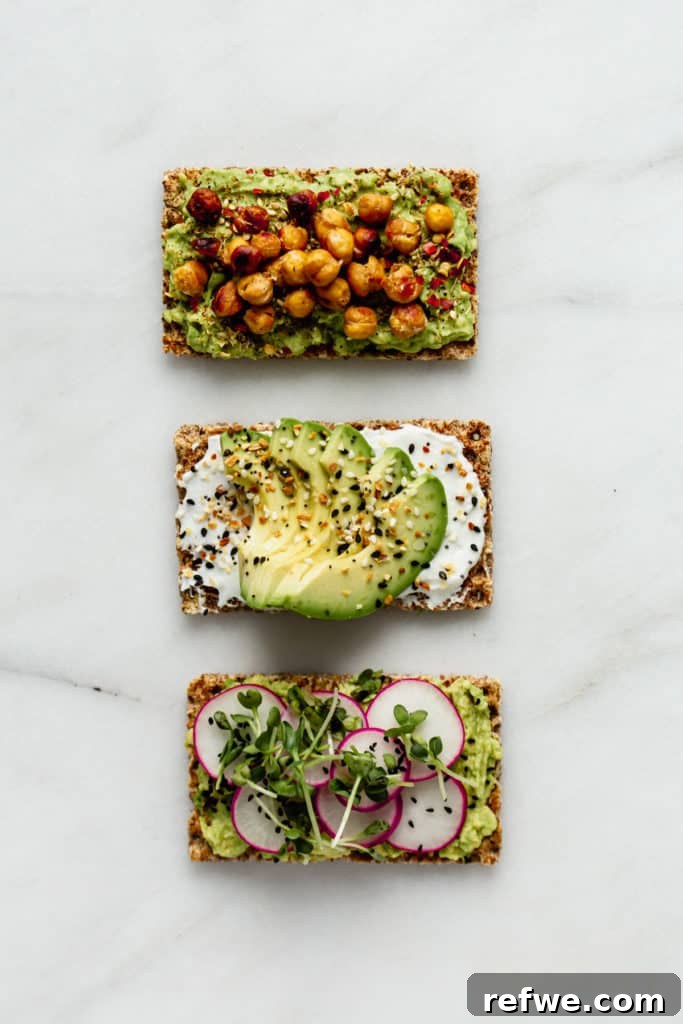 Avocado Toast: Three Creative Twists 4 A tantalizing close-up of three individual Ryvita crispbreads, each artfully topped with creamy avocado and unique, colorful additions, showcasing their appetizing appeal.