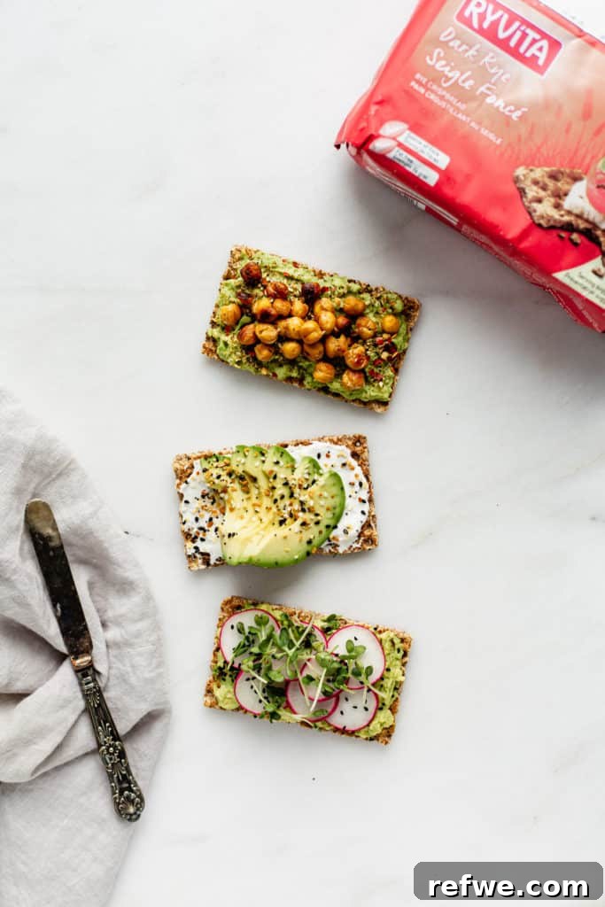 Avocado Toast: Three Creative Twists 8 A delightful arrangement of three avocado-topped Ryvita crispbreads, showcasing different flavor combinations, with a package of Ryvita in the background, ready for more delicious creations.