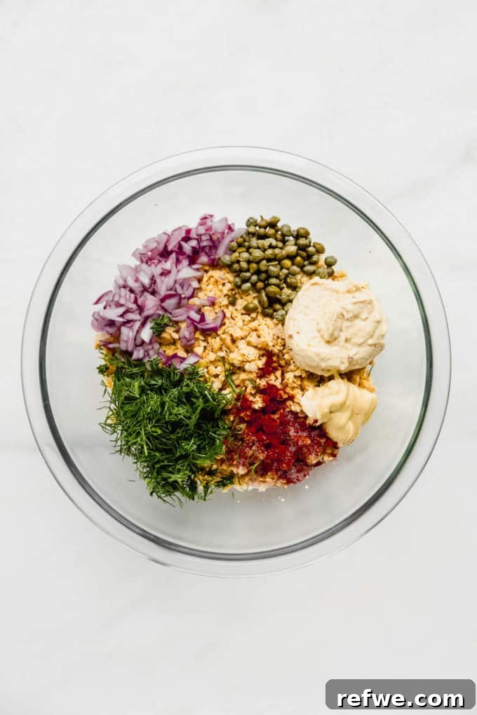 smashed chickpea salad ingredients in a clear mixing bowl