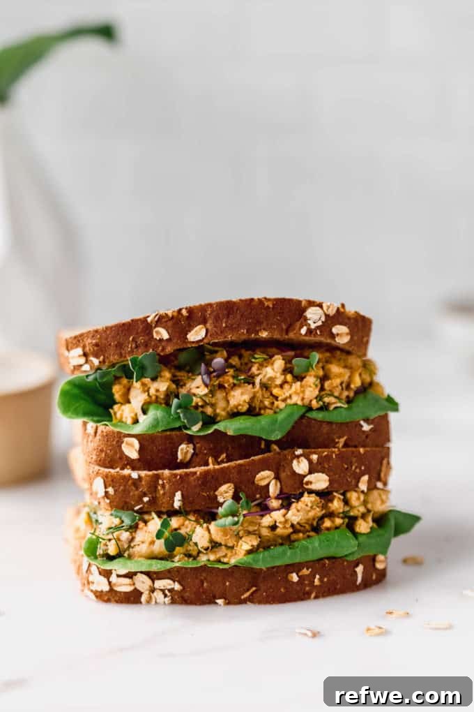 two smashed chickpea salad sandwiches stacked on top of each other