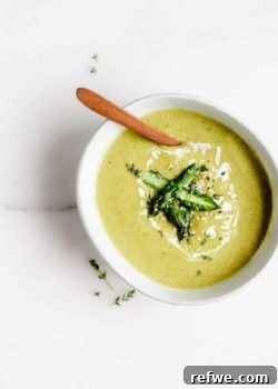 asparagus soup in a white bowl with chopped asparagus on top
