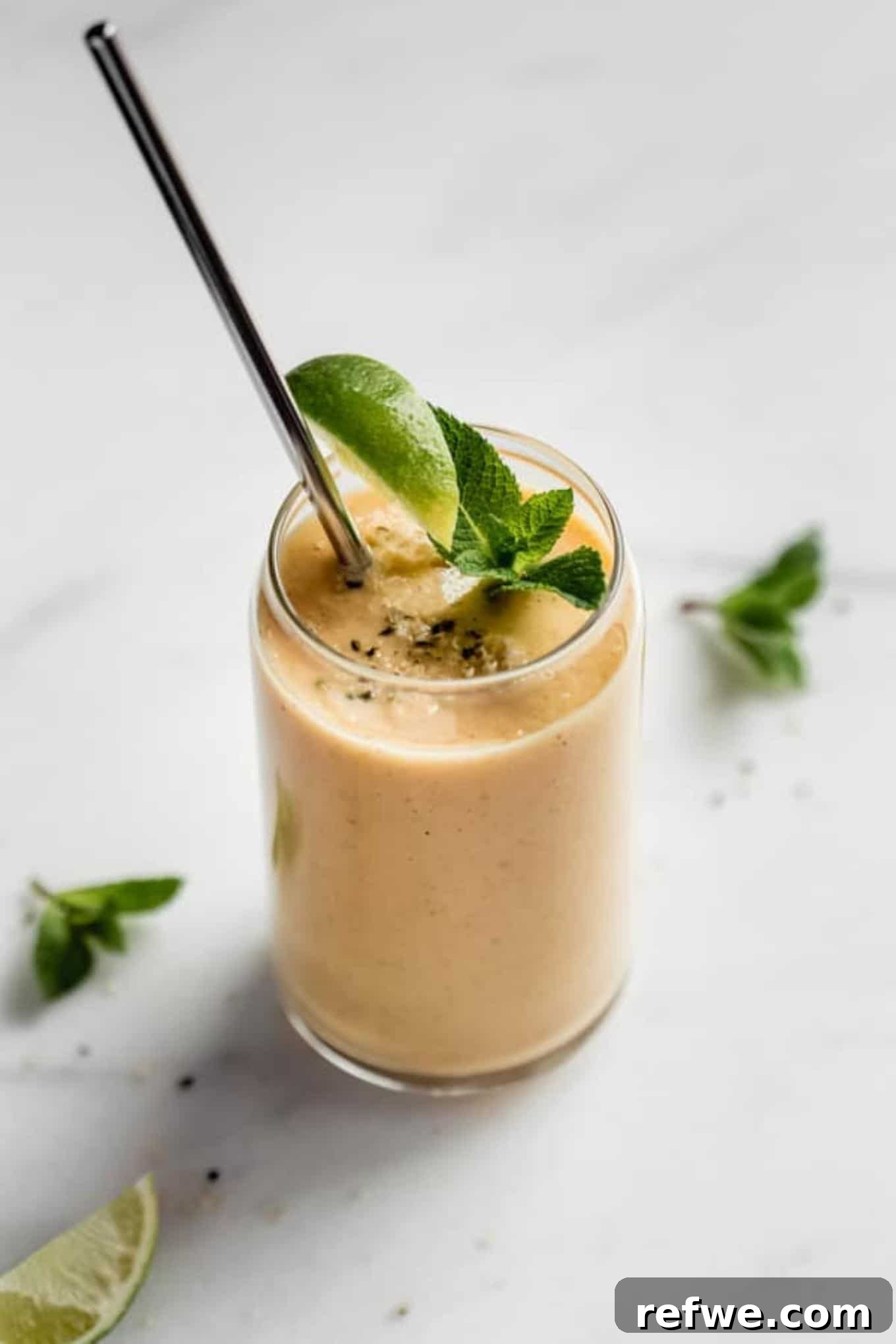 23 Simple Wholesome Morning Smoothies 23 A yellow smoothie topped with a sprig of mint and a lime wedge