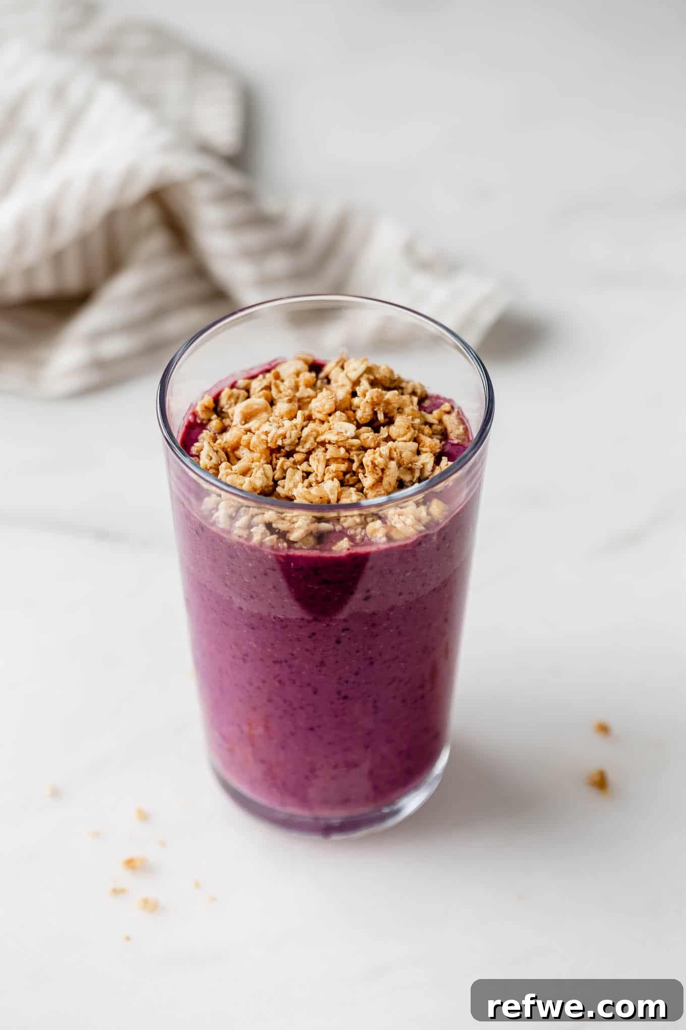 23 Simple Wholesome Morning Smoothies 7 An acai smoothie in a glass topped with granola