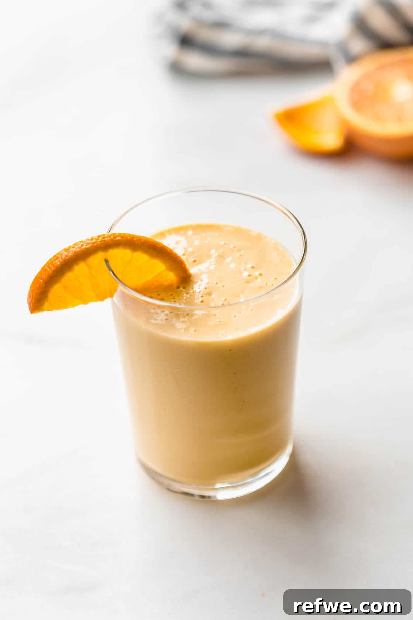 23 Simple Wholesome Morning Smoothies 9 an orange creamsicle smoothie with an orange slice in it