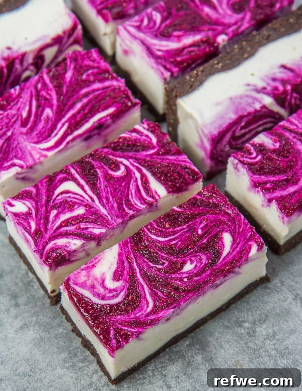 Healthy Vegan Dragon Fruit Dessert Vegan dragon fruit cheesecake bars arranged beautifully on a plate, ready to be served as a healthy, colorful dessert.