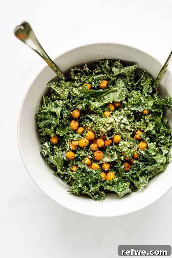 freshly chopped kale covered with smokey roasted chickpeas in a white bowl on a white marble countertop, summer salads with kale 