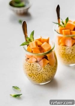a jar filled with mango chia pudding, cubed mangos and fresh mint