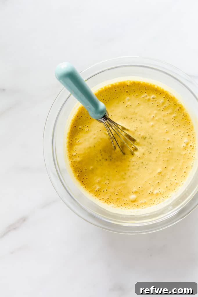 A clear glass mixing bowl containing the vibrant mango puree and chia seeds, ready to be combined.