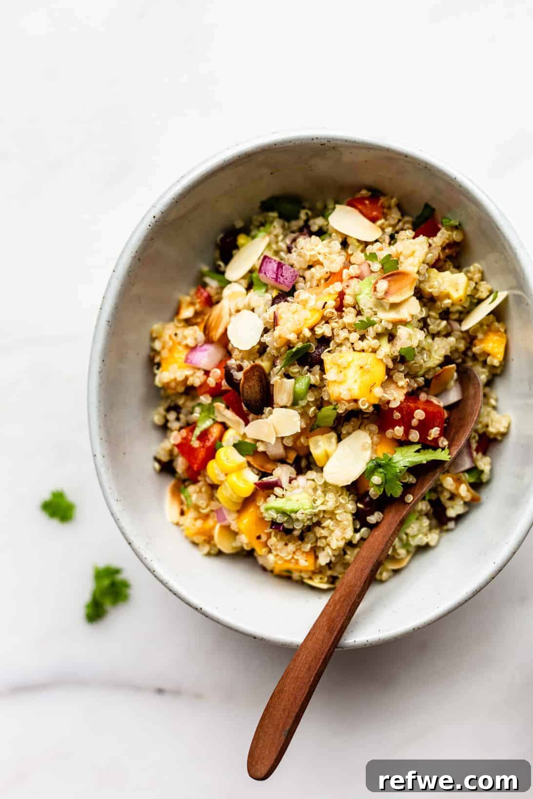 Zesty Southwestern Quinoa Power Bowl 2 A beautifully presented Southwest Quinoa Salad in a white bowl, with a rustic wooden spoon ready for serving.