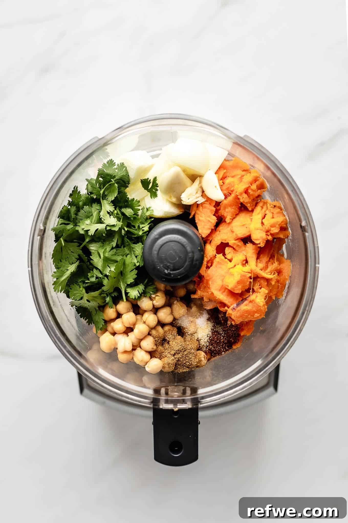 Sweet Potato and Chili Falafel 3 Sweet potato, chickpeas, onion, cilantro, and spices are placed inside a food processor bowl, ready to be blended.