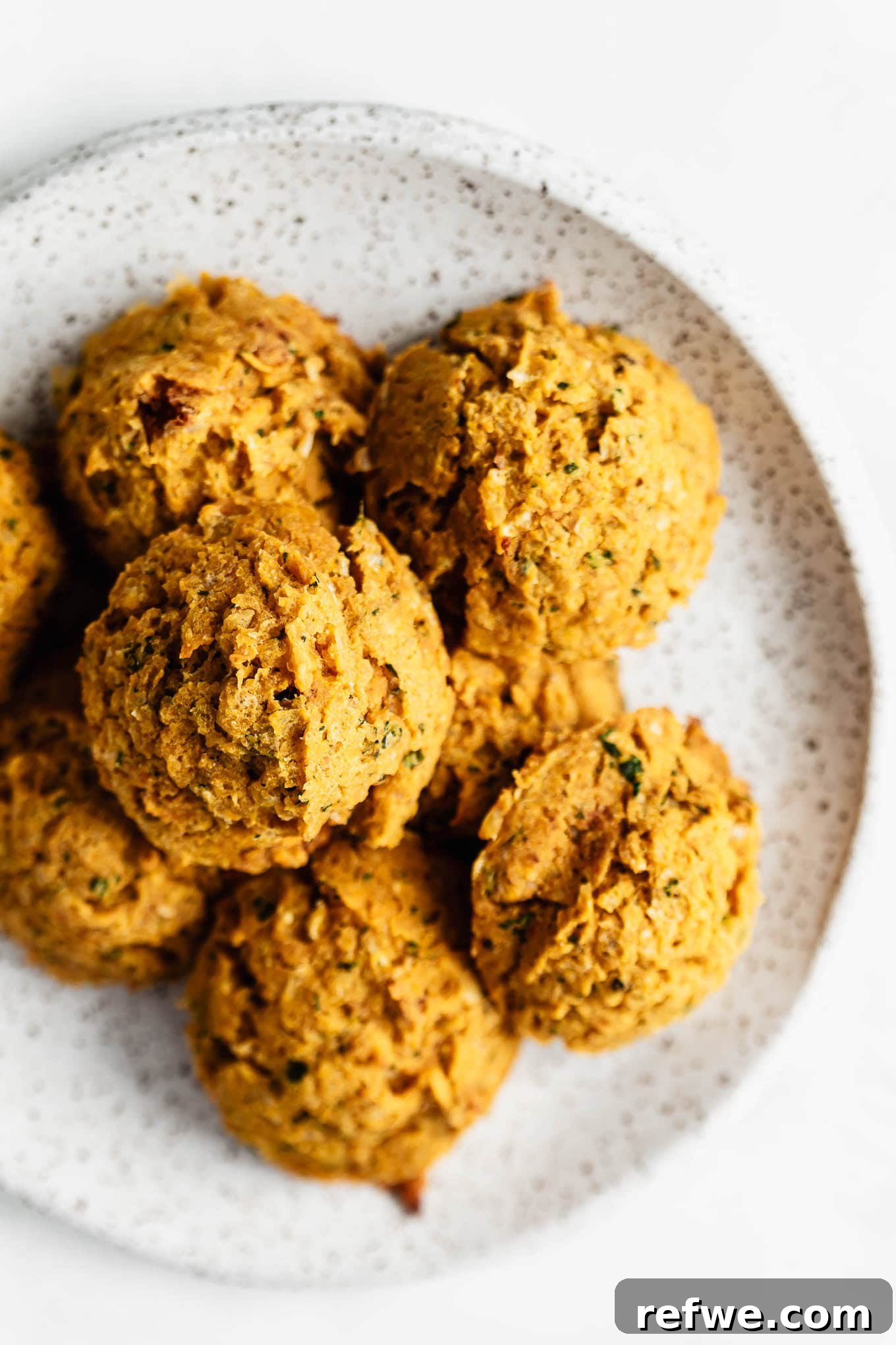 Sweet Potato and Chili Falafel 7 A stack of golden sweet potato falafel on a speckled white plate, ready to be served.
