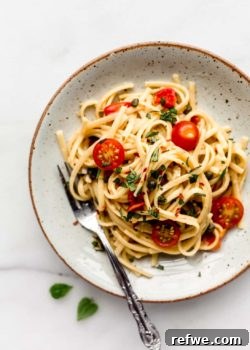 linguine pasta with cherry tomatoes on a white ceramic plate