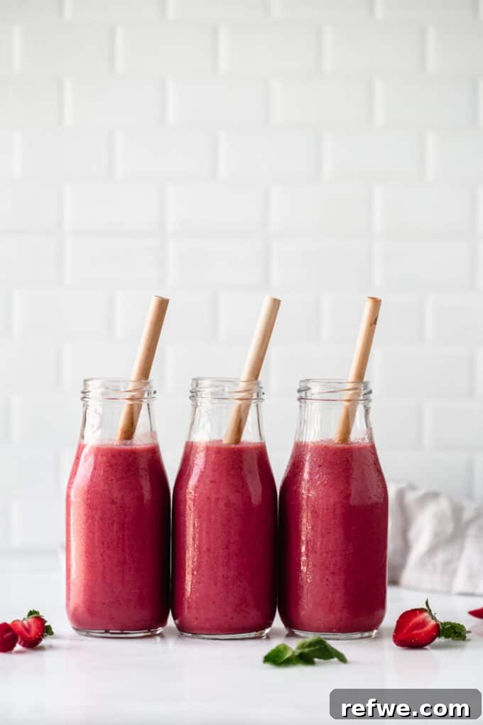 Crimson Chia Berry Delight 2 Three bottles of red berry chia smoothie with bamboo straws, showcasing a healthy and refreshing drink.