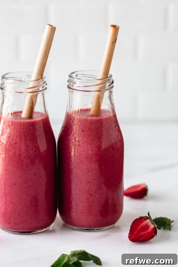 Crimson Chia Berry Delight 4 A vibrant red berry smoothie in a glass jar with a bamboo straw, set on a elegant marble board.